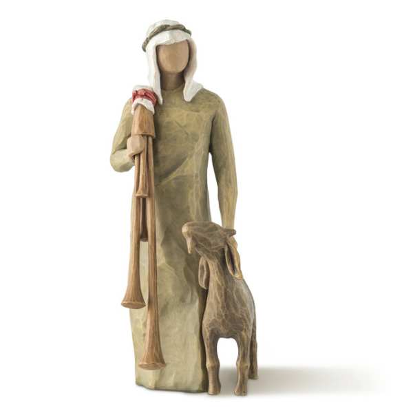 Carved figurine of a robed shepherd holding a staff beside a lamb