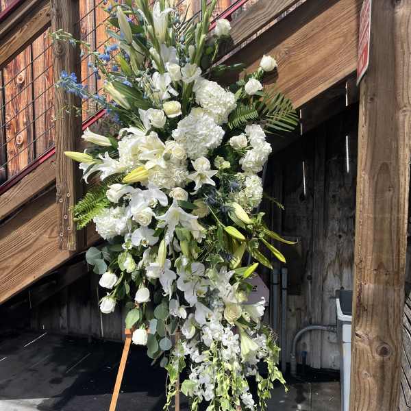 Tall white floral standing spray on an easel