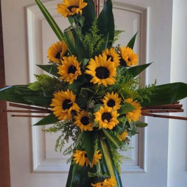 Standing sunflower spray on an easel with dark green foliage