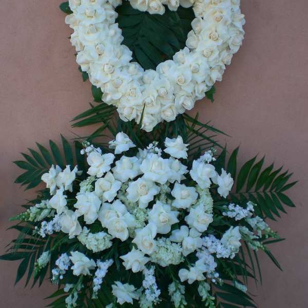 White floral funeral wreath with a matching spray below