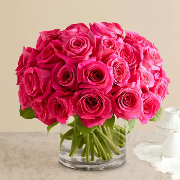 Bright pink roses arranged in a clear glass vase
