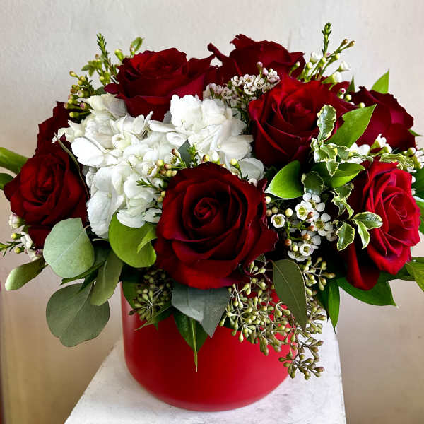 Red roses and white hydrangeas in a red vase