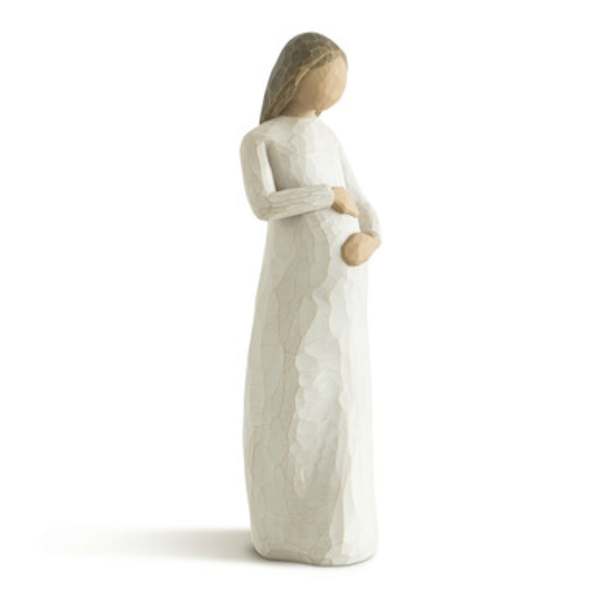Carved figurine of a standing woman in a cream dress