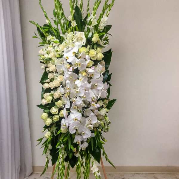 Tall standing floral spray with white orchids and cream roses