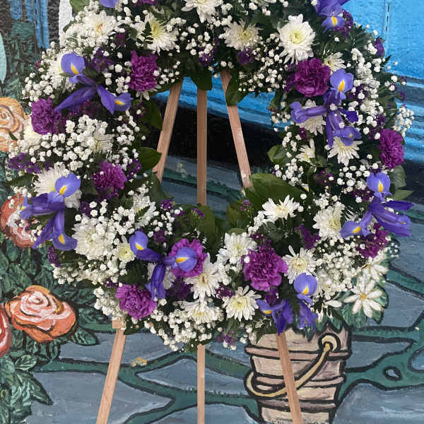 Purple and white floral wreath on a wooden easel