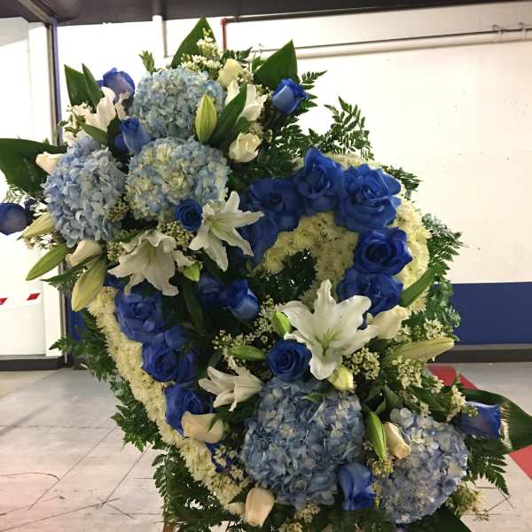Large blue and white floral standing spray with roses, lilies, and hydrangeas