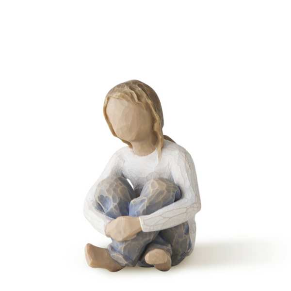 Wooden figurine of a seated child hugging their knees