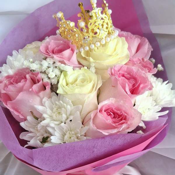 Pink and cream roses with white daisies and a gold crown topper