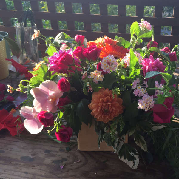 Mixed bouquet with pink and orange flowers in a low container
