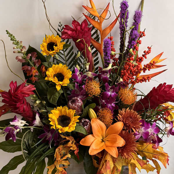 Colorful tropical bouquet with sunflowers, lilies, orchids, and orange bird-of-paradise
