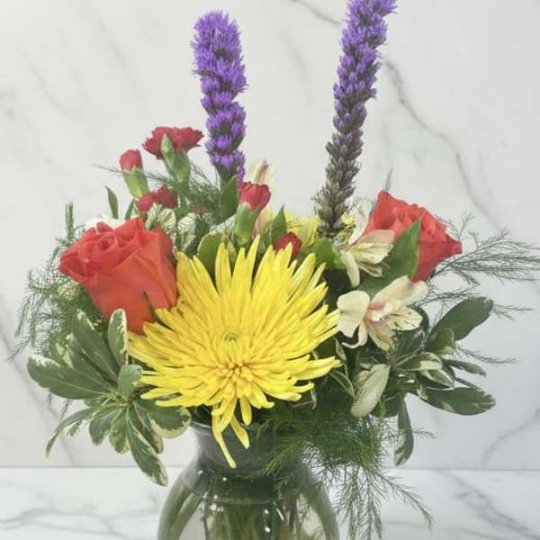 Bouquet of yellow and red flowers in a glass vase