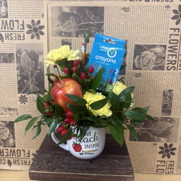 Yellow carnations and an apple in a mug with crayons