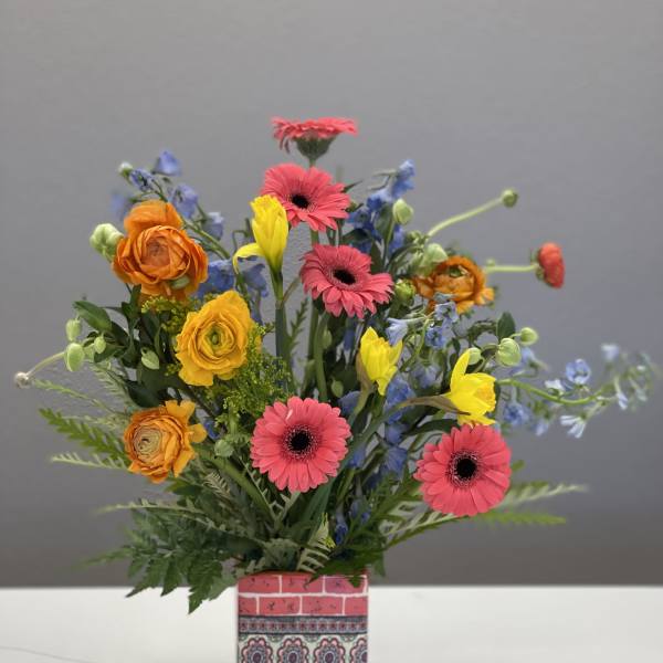 Colorful mixed bouquet in a patterned square vase