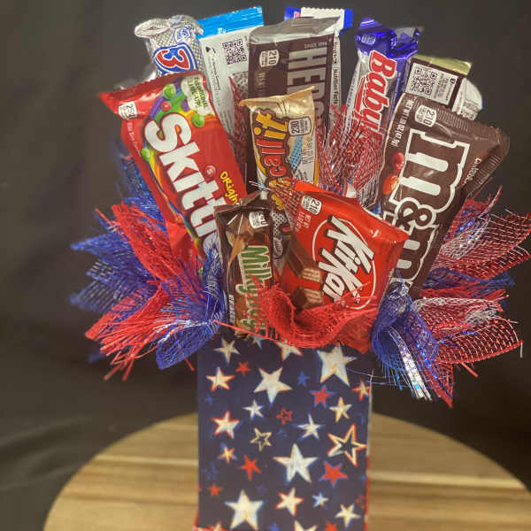 Candy bouquet in a star-patterned gift bag with red and blue mesh accents