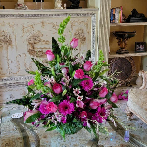 Pink floral arrangement with roses, lilies, and gerbera daisies in a low vase