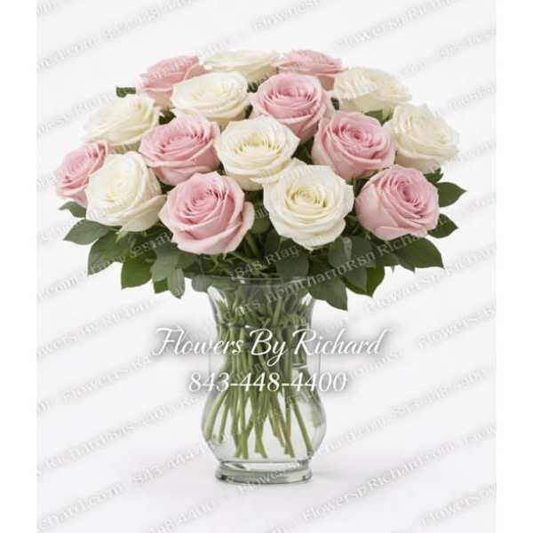 Pink and white roses arranged in a clear glass vase
