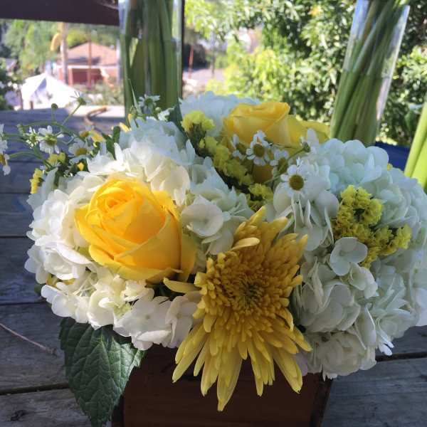 Yellow roses and white hydrangeas in a wooden box