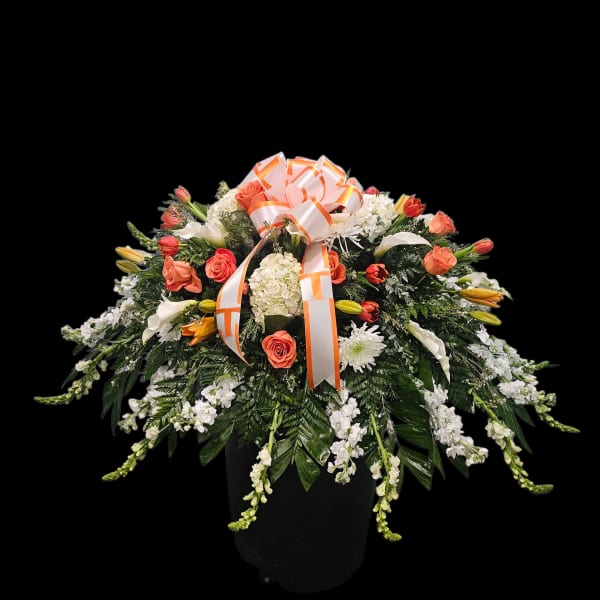 Large floral arrangement in a black vase with orange ribbon