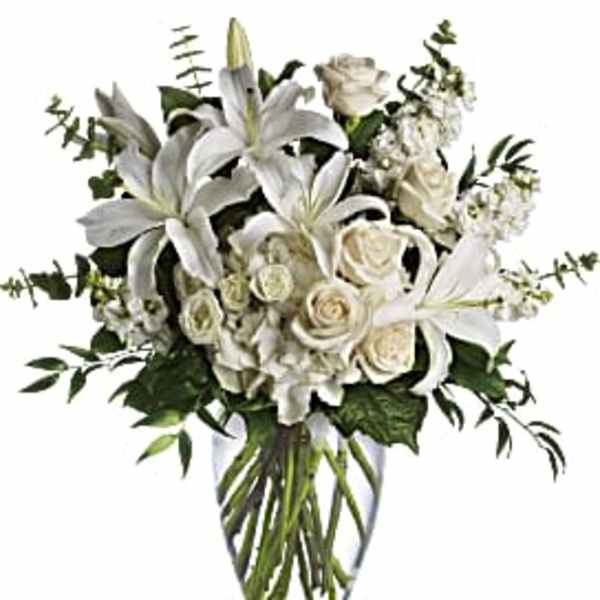 White lilies and roses in a clear glass vase
