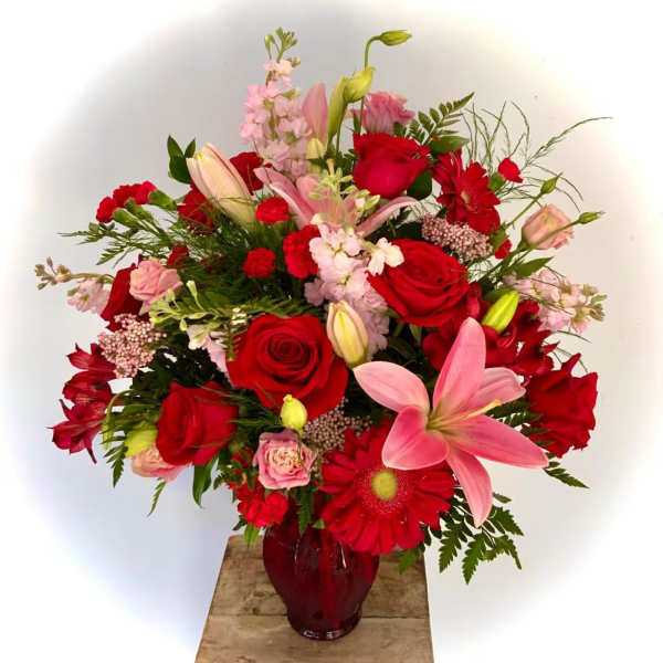 Red and pink mixed bouquet in a red glass vase