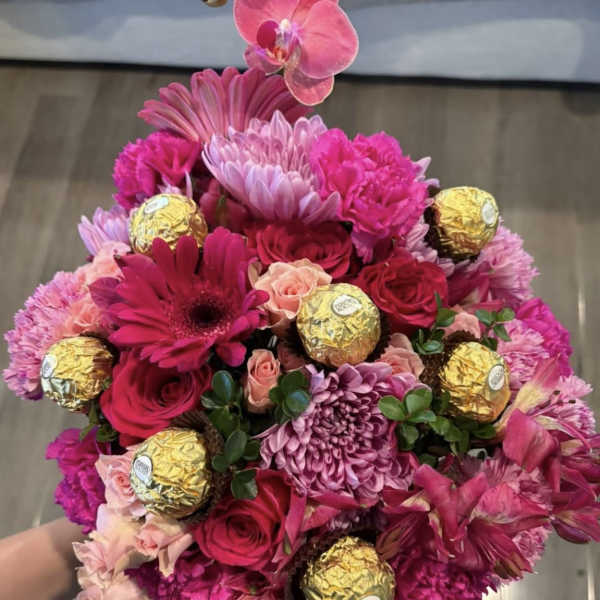 Pink bouquet with roses, chrysanthemums, orchids, and gold-wrapped chocolates