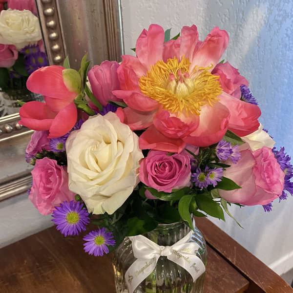Pink and white roses with a large pink peony in a glass vase