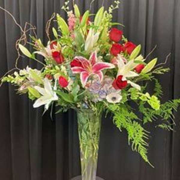 Tall vase arrangement with red roses and pink-and-white lilies