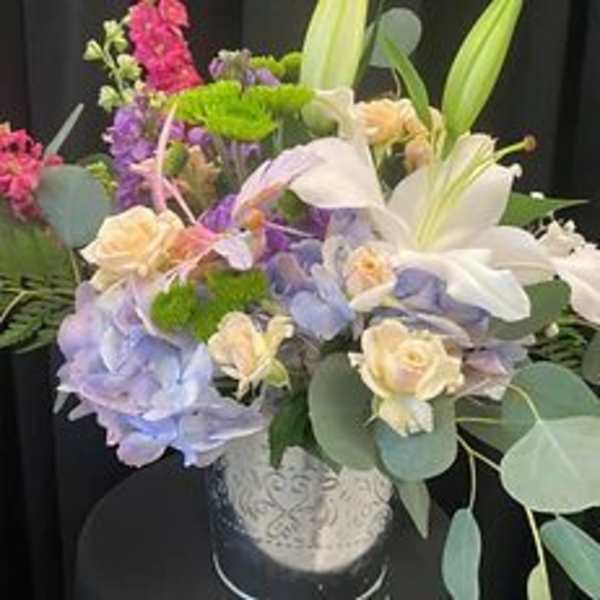 Mixed bouquet with lilies, roses, and hydrangeas in a decorative vase