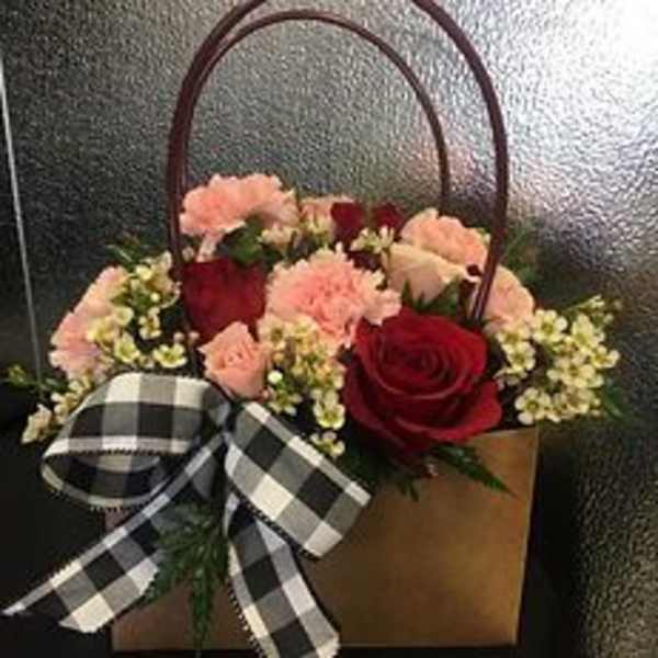 Basket of red roses and pink carnations with a black-and-white ribbon