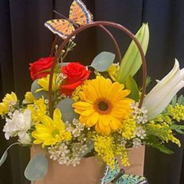 Basket arrangement with red and yellow flowers and butterfly decorations