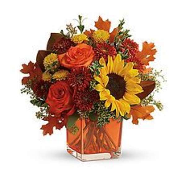 Autumn bouquet with sunflowers and roses in an orange vase