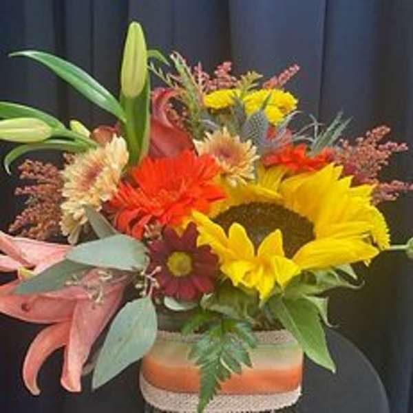 Mixed bouquet with sunflowers, lilies, and gerbera daisies in a rectangular vase