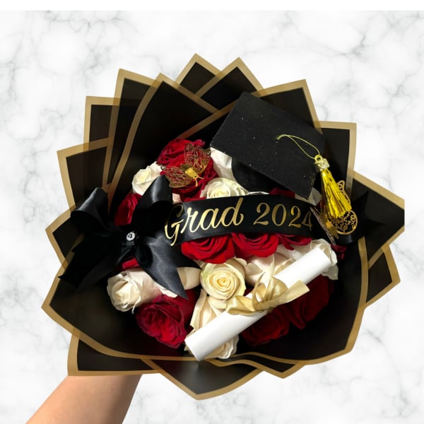 Bouquet of red and white roses with a graduation cap and "Grad 2024" ribbon
