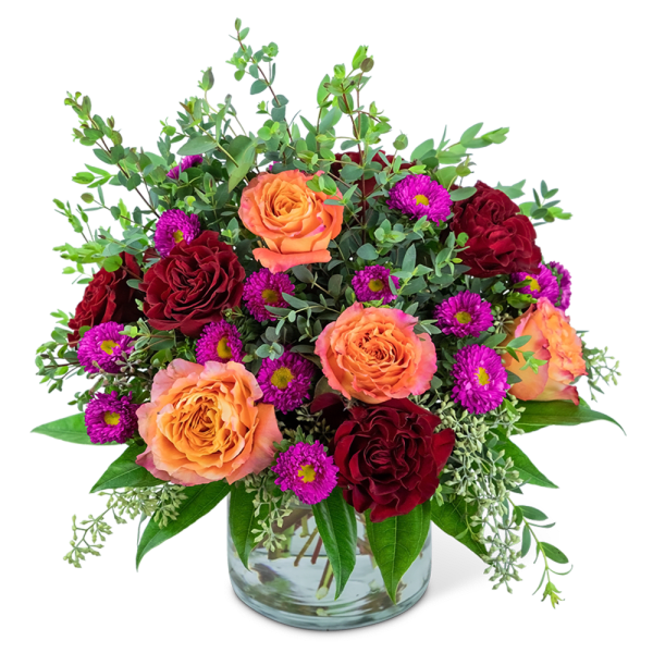 Orange and red roses with purple daisies in a glass vase