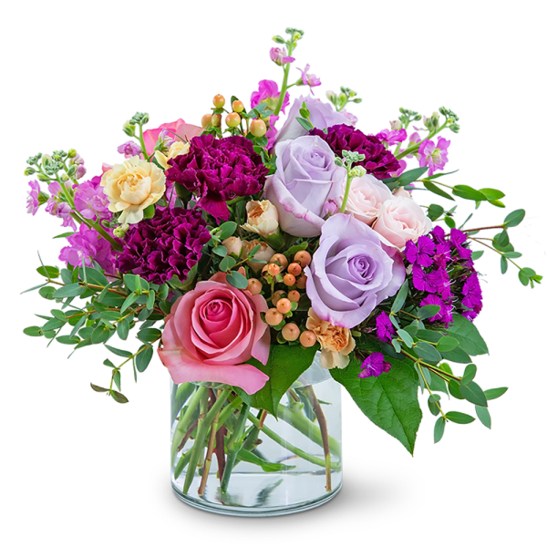 Mixed bouquet of pink, lavender, and purple roses in a glass vase