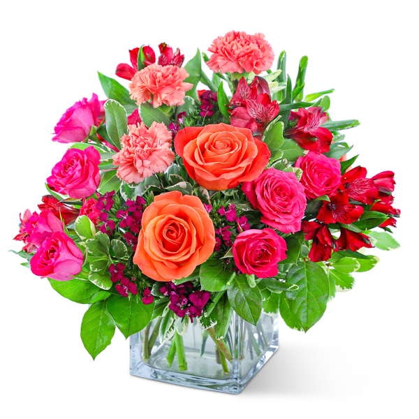 Mixed pink and orange flowers in a clear glass vase
