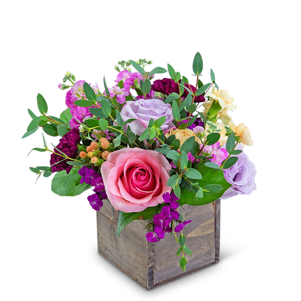 Mixed pink, lavender, and yellow flowers in a wooden box