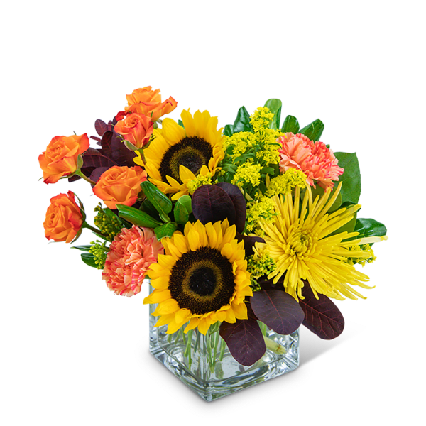 Sunflowers, orange roses, and yellow chrysanthemums in a square glass vase
