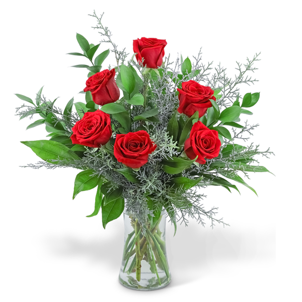 Red roses in a clear glass vase with silver foliage