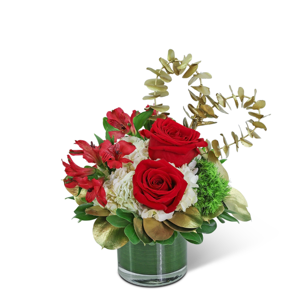 Red roses and white hydrangeas in a glass vase with gold foliage accents