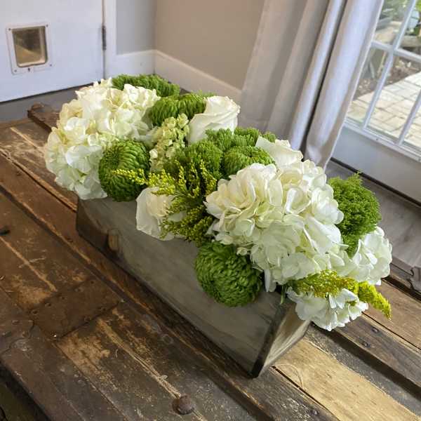 White and green floral arrangement in a rectangular wooden box