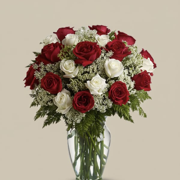Red and white roses arranged in a clear glass vase