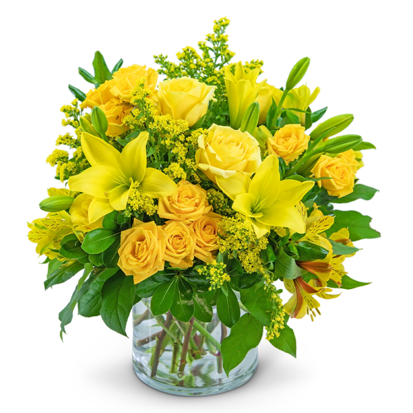 Yellow roses and lilies arranged in a clear glass vase