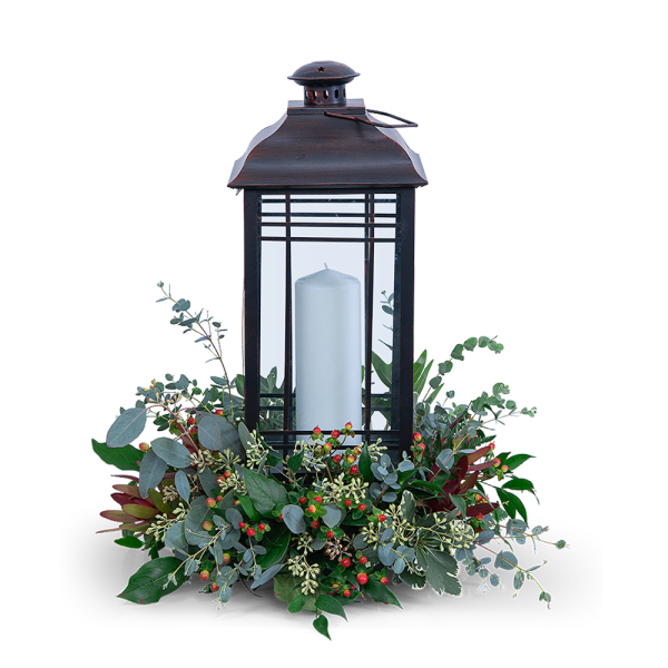 Black lantern with a white candle and greenery base