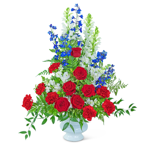 Tall red, white, and blue floral arrangement in a white vase