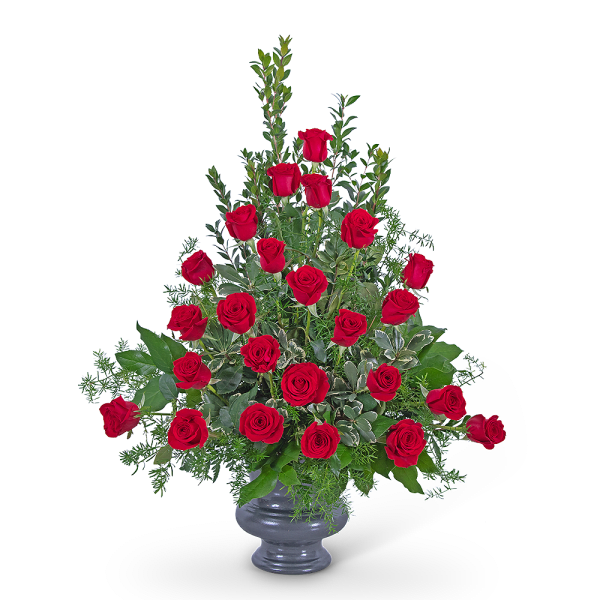 Red roses arranged in a gray vase with greenery