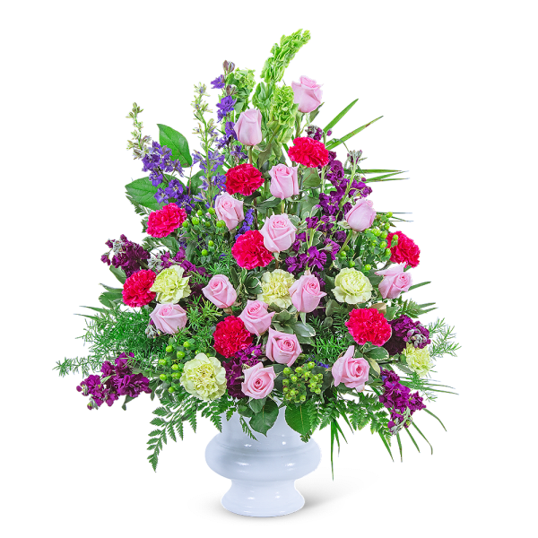 Pink roses and purple flowers in a white pedestal vase