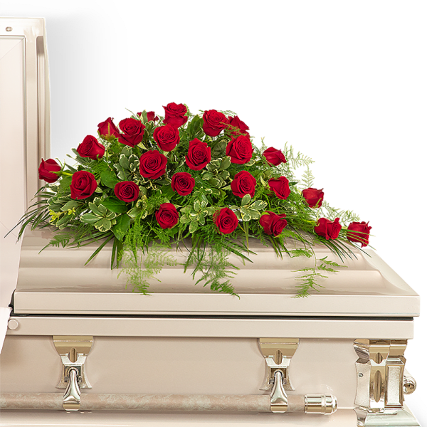 Red rose spray on a white casket