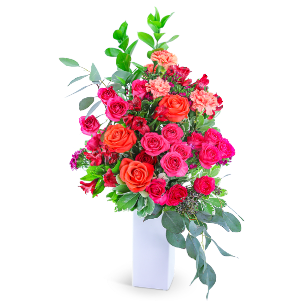 Tall bouquet of pink and orange roses in a white vase