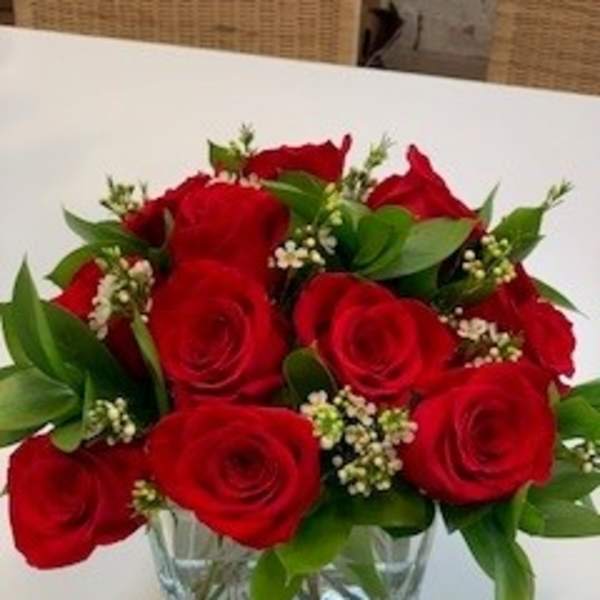 Red roses arranged in a clear glass vase